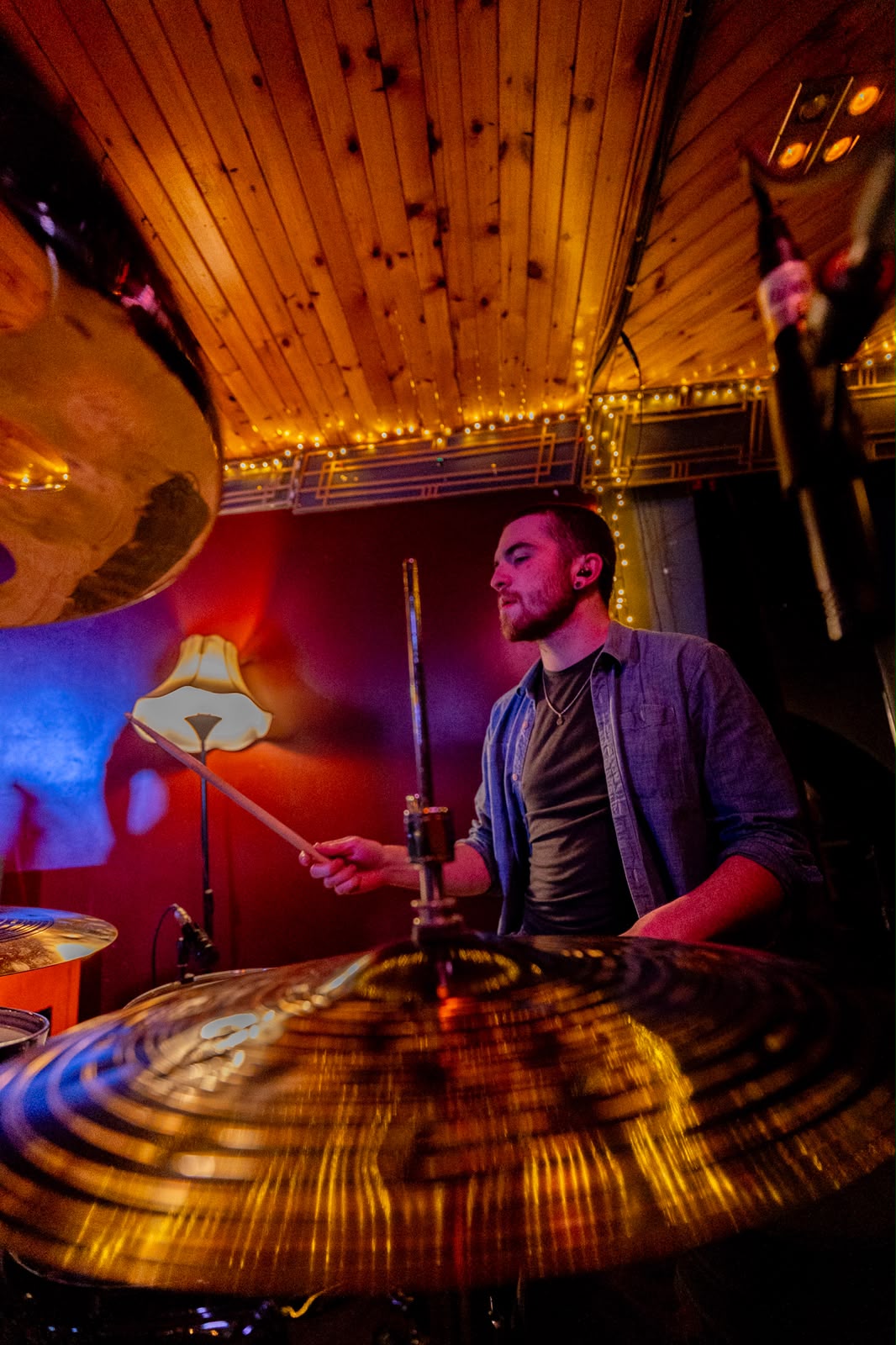 Drummer under warm stage lighting