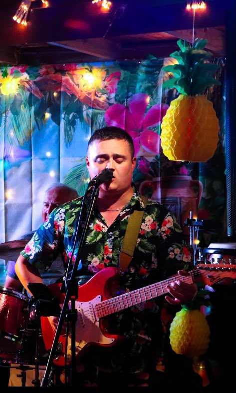 Singer performing with colorful tropical stage lighting